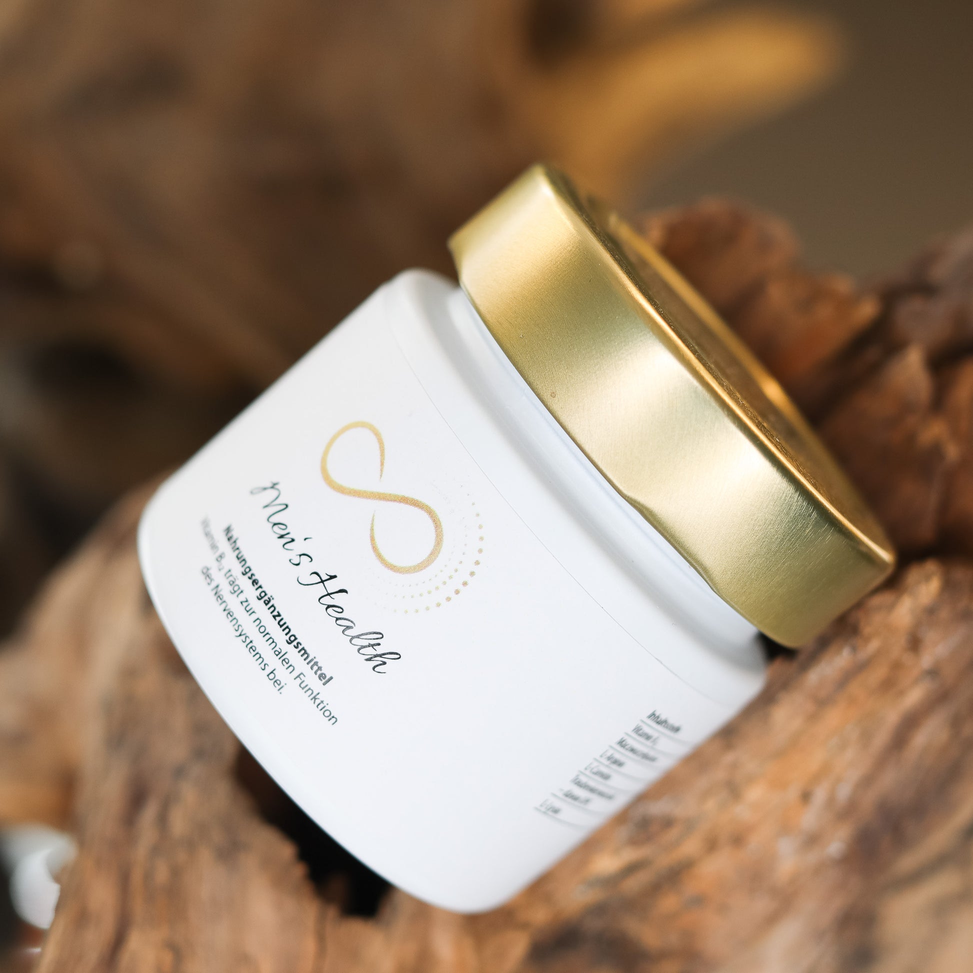 Produktbild eines Nahrungsergänzungsmittels im weißen Glas mit goldenem Deckel, liegend auf natürlichem Holzuntergrund. Abgebildet ist das Produkt „Mens Health“ aus der ANS Nutrivity Secrets Serie – hochwertiges Supplement, fotografiert zur Veranschaulichung der Verpackung. Die genaue Zusammensetzung und Anwendungshinweise sind der Produktbeschreibung im Shop zu entnehmen.