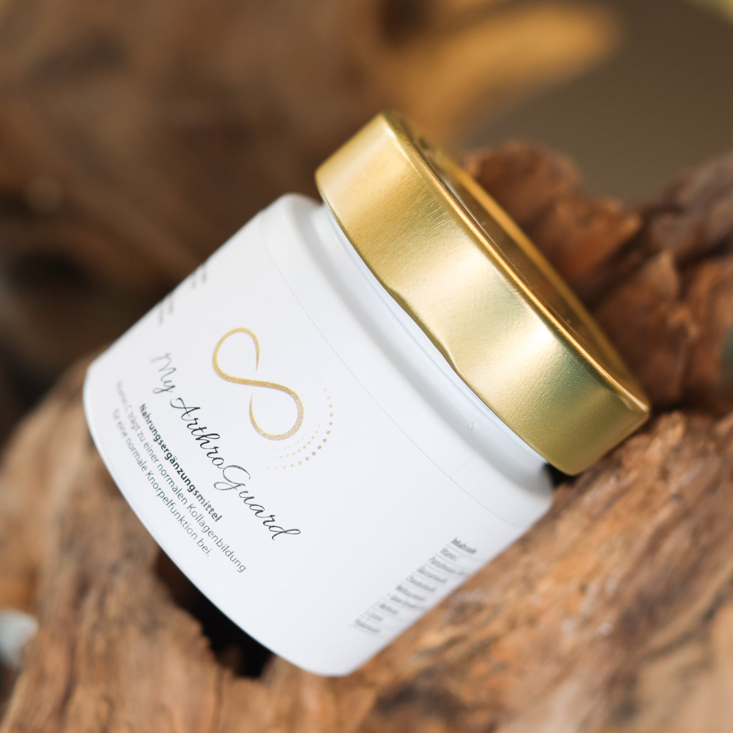 Produktbild eines Nahrungsergänzungsmittels im weißen Glas mit goldenem Deckel, liegend auf natürlichem Holzuntergrund. Abgebildet ist das Produkt „My ArthraGuard“ aus der ANS Nutrivity Secrets Serie – hochwertiges Supplement, fotografiert zur Veranschaulichung der Verpackung. Die genaue Zusammensetzung und Anwendungshinweise sind der Produktbeschreibung im Shop zu entnehmen.