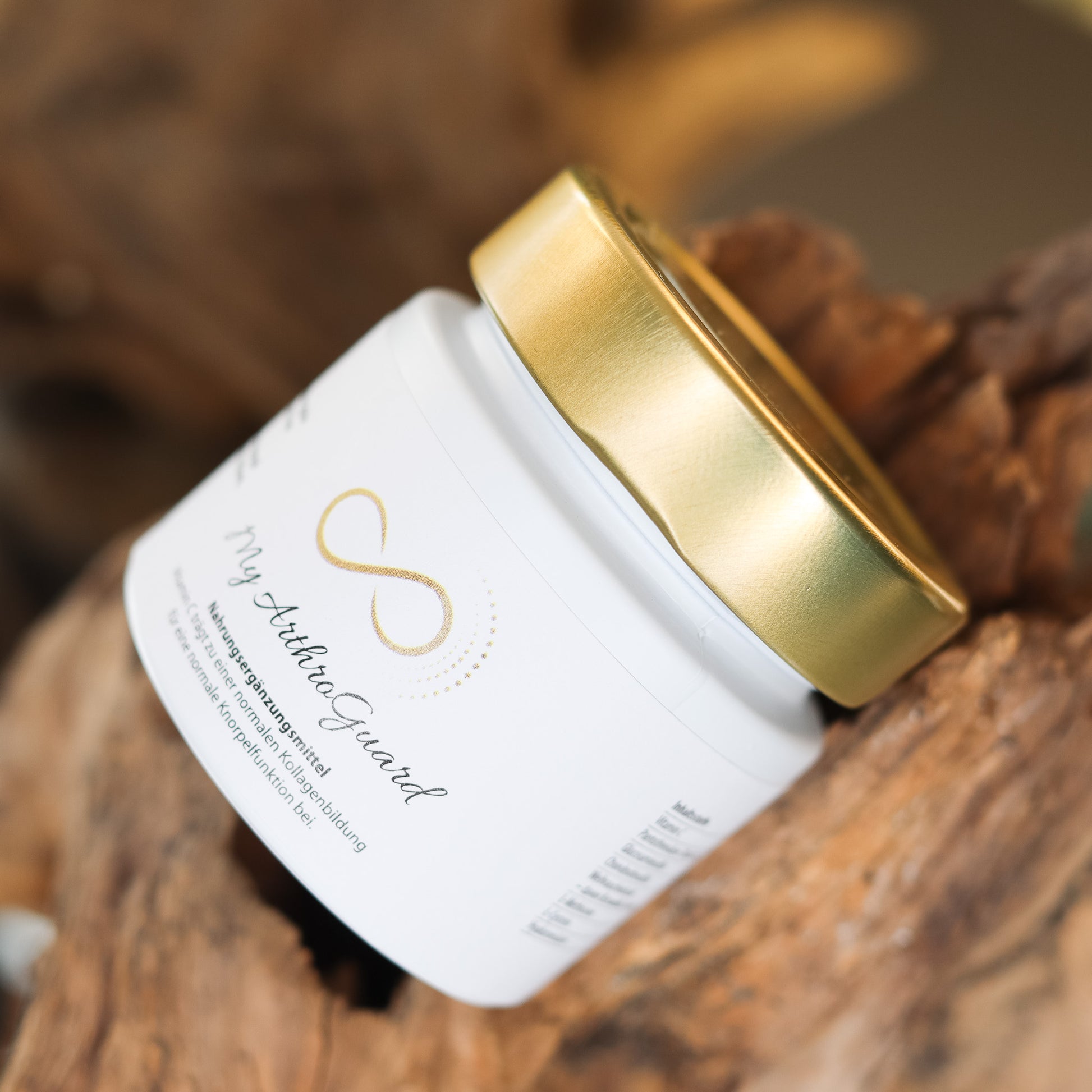 Produktbild eines Nahrungsergänzungsmittels im weißen Glas mit goldenem Deckel, liegend auf natürlichem Holzuntergrund. Abgebildet ist das Produkt „My ArthraGuard“ aus der ANS Nutrivity Secrets Serie – hochwertiges Supplement, fotografiert zur Veranschaulichung der Verpackung. Die genaue Zusammensetzung und Anwendungshinweise sind der Produktbeschreibung im Shop zu entnehmen.