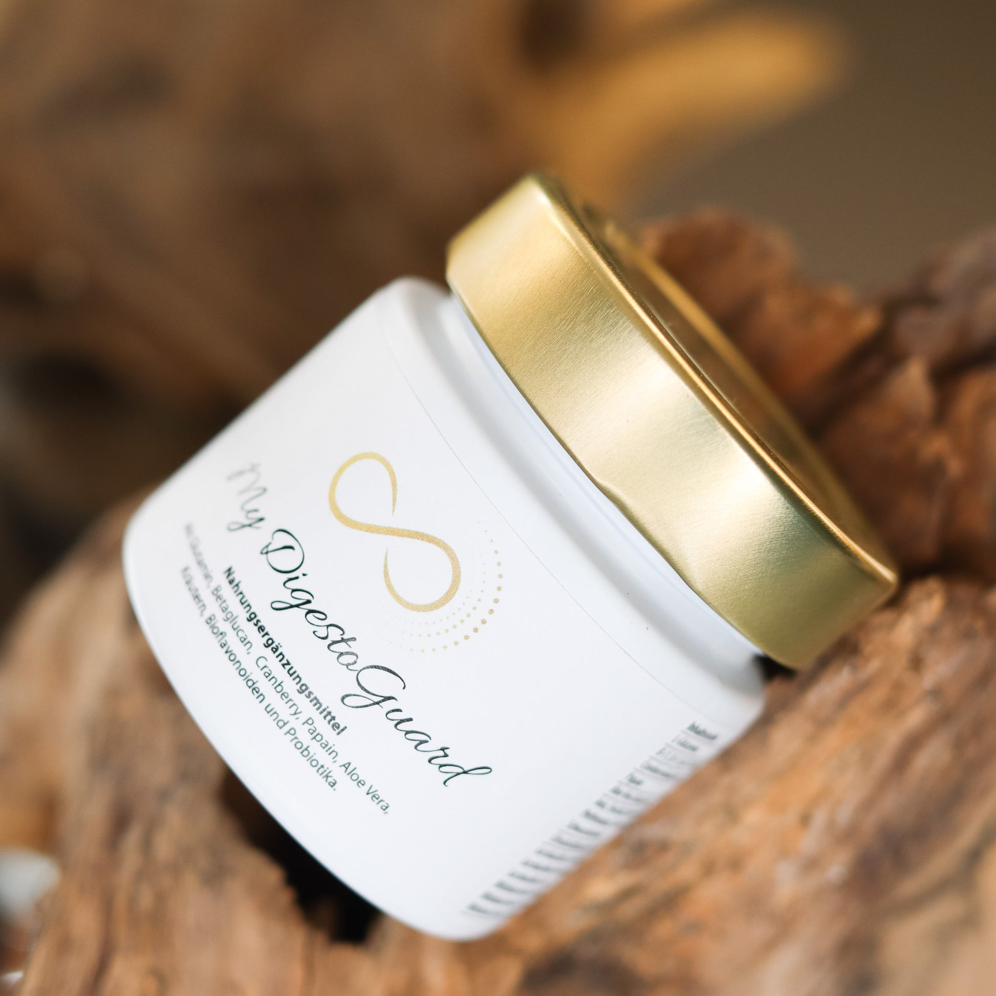 Produktbild eines Nahrungsergänzungsmittels im weißen Glas mit goldenem Deckel, liegend auf natürlichem Holzuntergrund. Abgebildet ist das Produkt „My DigestoGuard“ aus der ANS Nutrivity Secrets Serie – hochwertiges Supplement, fotografiert zur Veranschaulichung der Verpackung. Die genaue Zusammensetzung und Anwendungshinweise sind der Produktbeschreibung im Shop zu entnehmen.