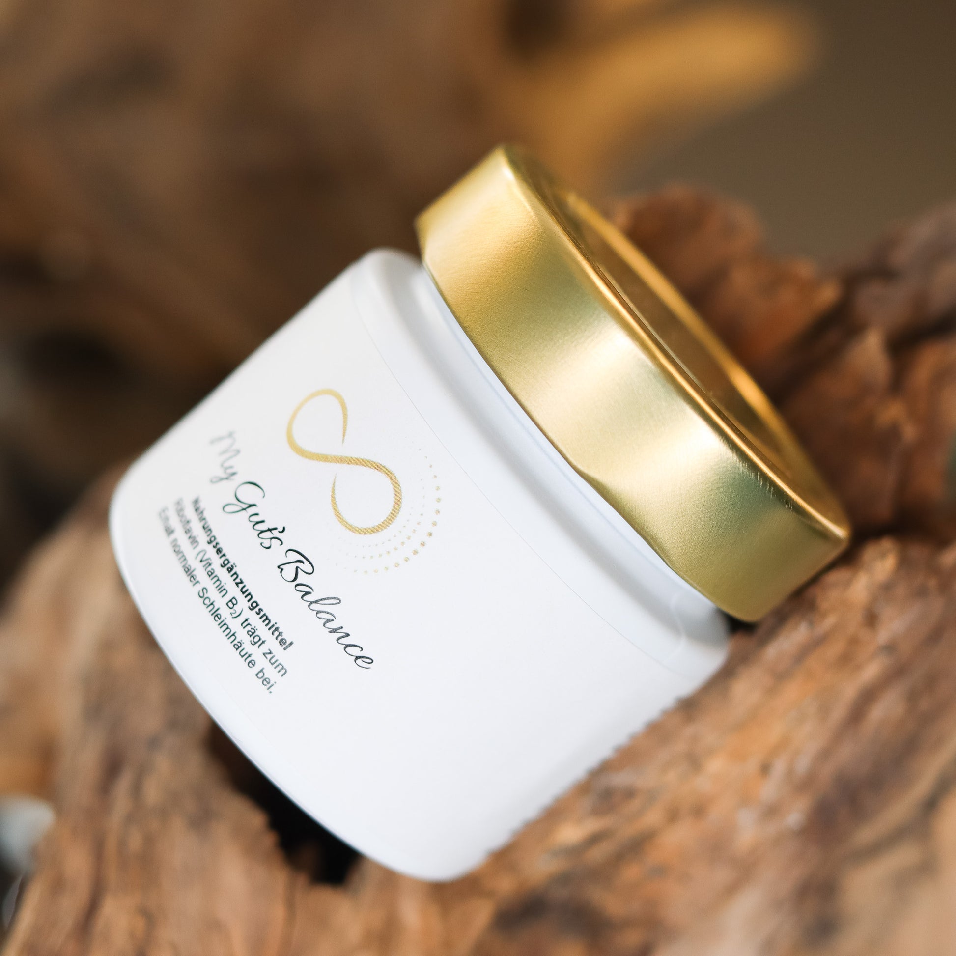 Produktbild eines Nahrungsergänzungsmittels im weißen Glas mit goldenem Deckel, liegend auf natürlichem Holzuntergrund. Abgebildet ist das Produkt „My Guts Balance“ aus der ANS Nutrivity Secrets Serie – hochwertiges Supplement, fotografiert zur Veranschaulichung der Verpackung. Die genaue Zusammensetzung und Anwendungshinweise sind der Produktbeschreibung im Shop zu entnehmen.