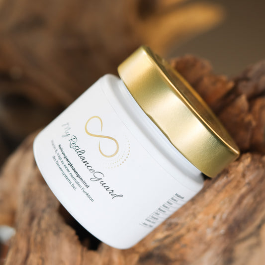 Produktbild eines Nahrungsergänzungsmittels im weißen Glas mit goldenem Deckel, liegend auf natürlichem Holzuntergrund. Abgebildet ist das Produkt „My ResilianceGuard“ aus der ANS Nutrivity Secrets Serie – hochwertiges Supplement, fotografiert zur Veranschaulichung der Verpackung. Die genaue Zusammensetzung und Anwendungshinweise sind der Produktbeschreibung im Shop zu entnehmen.
