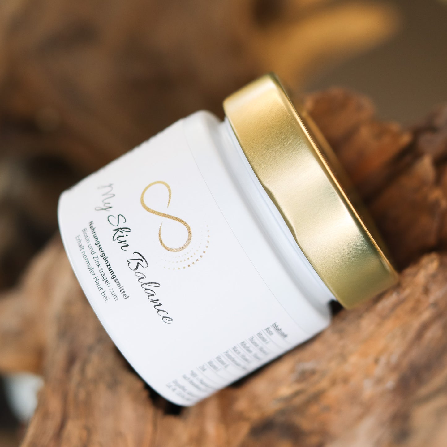 Produktbild eines Nahrungsergänzungsmittels im weißen Glas mit goldenem Deckel, liegend auf natürlichem Holzuntergrund. Abgebildet ist das Produkt „My Skin Balance“ aus der ANS Nutrivity Secrets Serie – hochwertiges Supplement, fotografiert zur Veranschaulichung der Verpackung. Die genaue Zusammensetzung und Anwendungshinweise sind der Produktbeschreibung im Shop zu entnehmen.