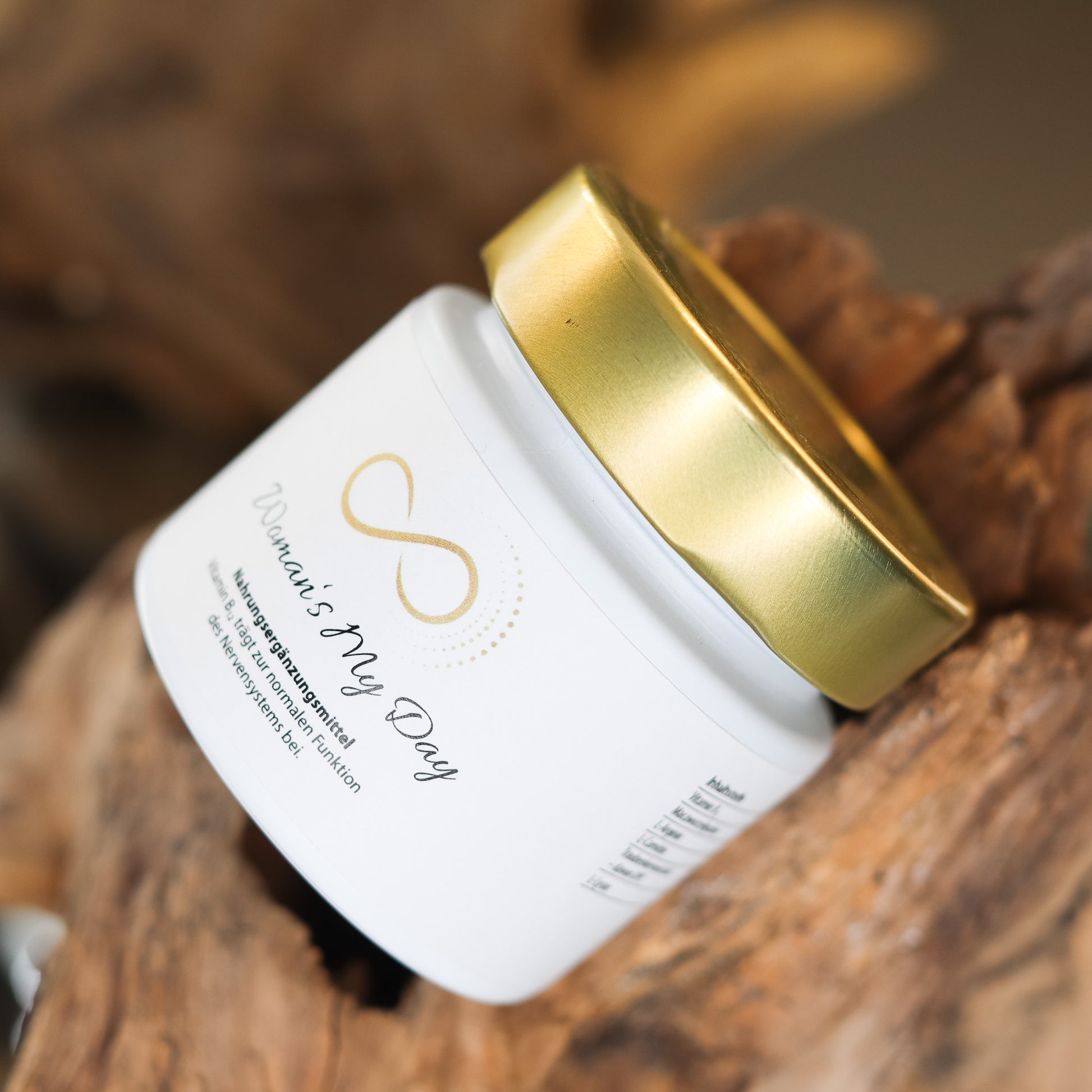 Produktbild eines Nahrungsergänzungsmittels im weißen Glas mit goldenem Deckel, liegend auf natürlichem Holzuntergrund. Abgebildet ist das Produkt „Womans My Day“ aus der ANS Nutrivity Secrets Serie – hochwertiges Supplement, fotografiert zur Veranschaulichung der Verpackung. Die genaue Zusammensetzung und Anwendungshinweise sind der Produktbeschreibung im Shop zu entnehmen.